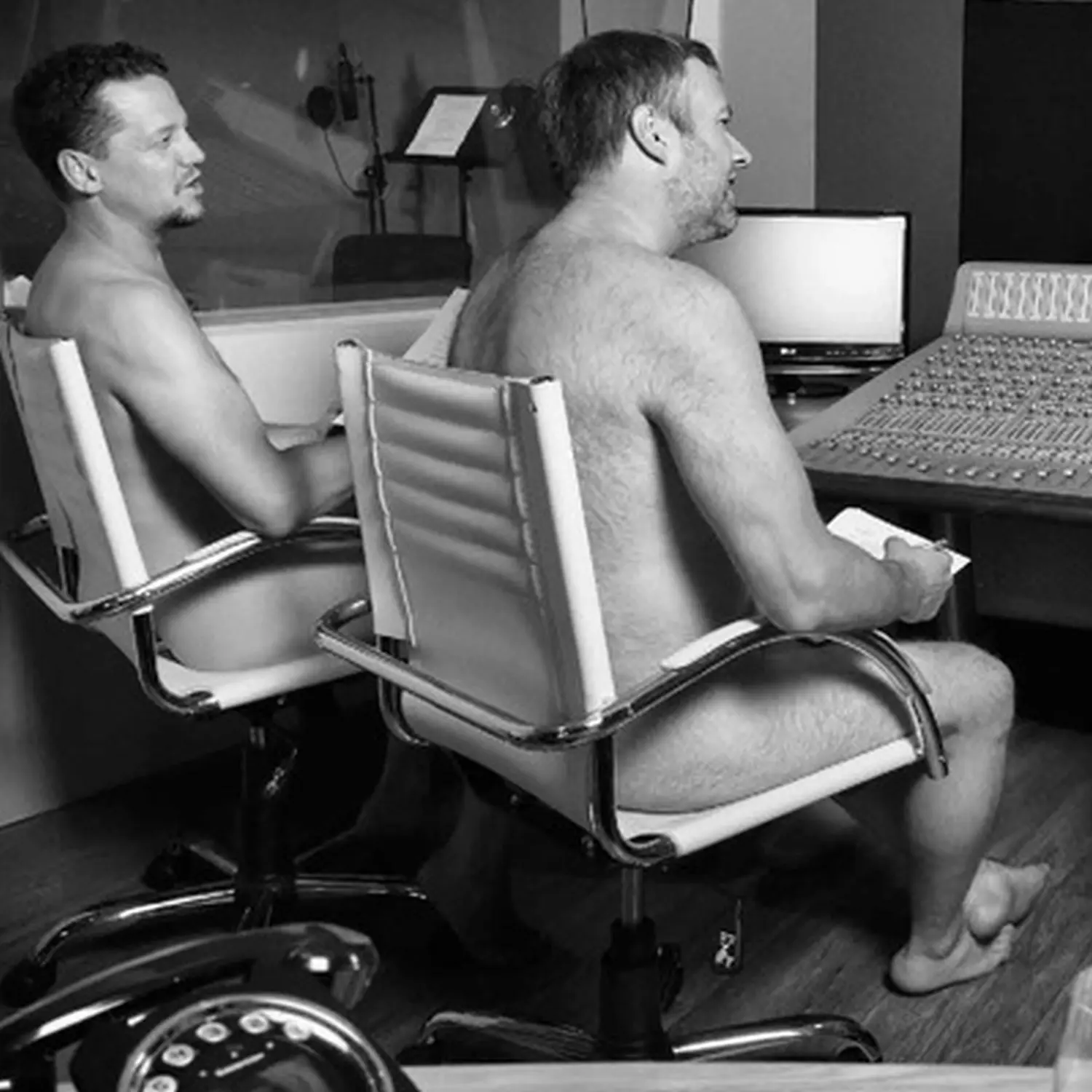 two naked mans sitting on a chair
